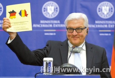 德国外长弗兰克－瓦尔特・施泰因迈尔手举图册，但封面上左侧位置的德国国旗却被错印在法国地图轮廓内。图/东方IC